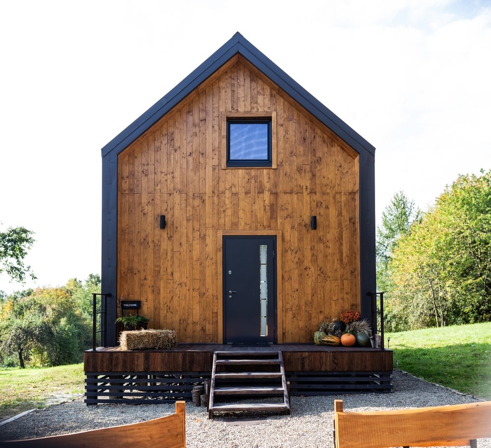 Modern Scandinavian-style tiny house with warm wood siding and metal roof