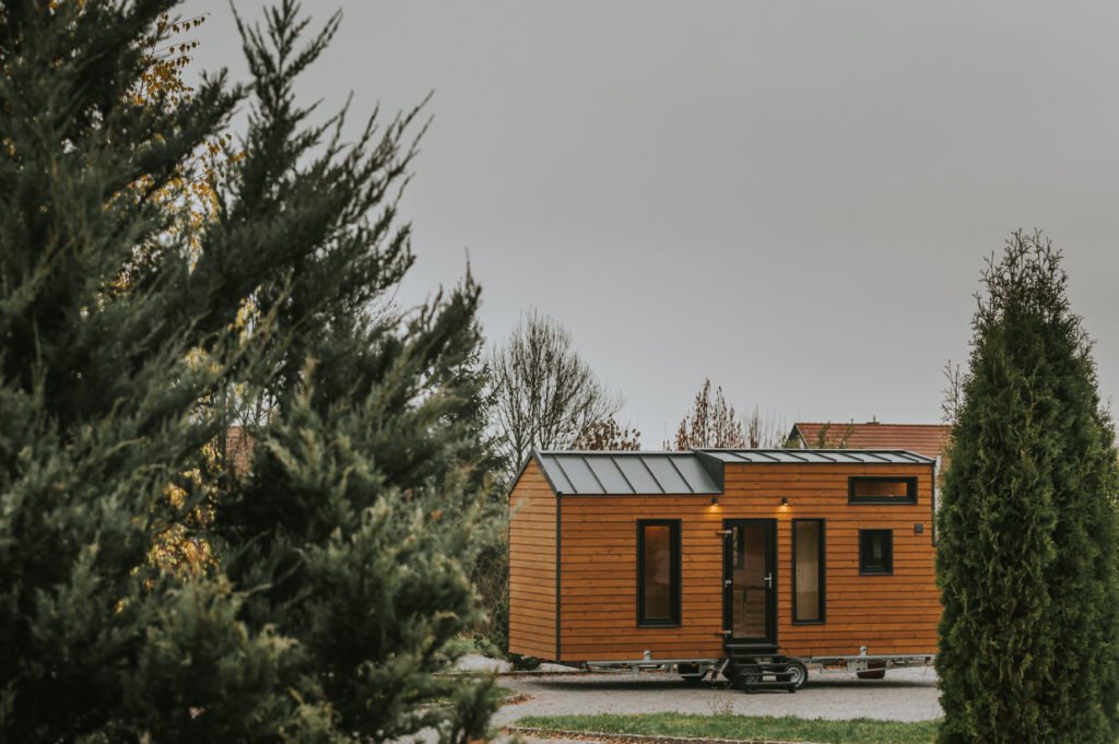 Modern tiny house on wheels surrounded by trees
